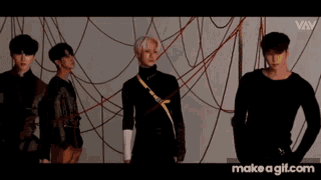 a group of men are standing next to each other in front of a red rope .