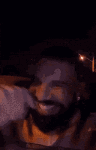 a man with a beard is smiling in a car .