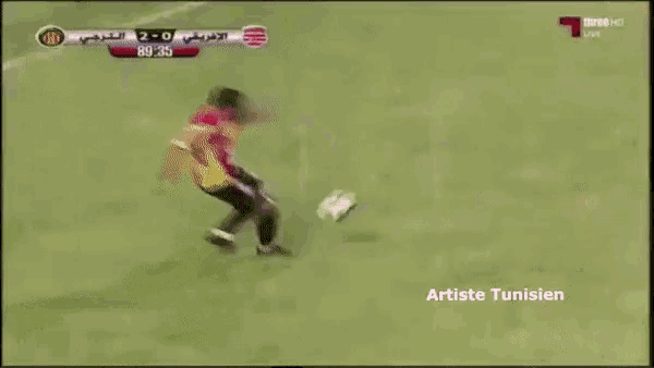 a soccer goalie jumps to catch a ball during a game sponsored by tunisie