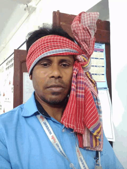 a man wearing a head scarf and a lanyard that says ' govt of orissa ' on it