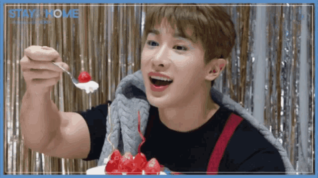 a man is eating a cake with a spoon and the words stay home on the bottom right