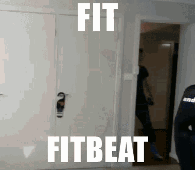 a person is standing in front of a door with the words fitbeat written on it .
