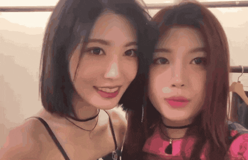 two women posing for a picture with one wearing a pink shirt