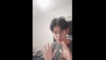 a young man is waving his hand in front of a wall that says ok buddy