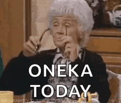 an elderly woman is sitting at a table with glasses in her hand and says `` oneka today '' .