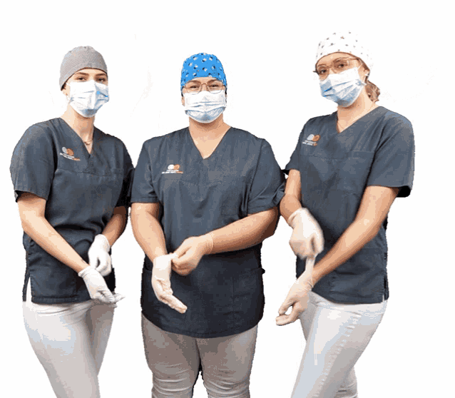 three female nurses wearing scrubs and masks are standing next to each other with one wearing a hat that says dental