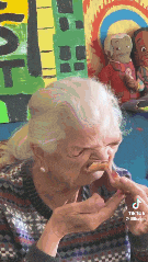 an elderly woman is making a funny face while eating a snack