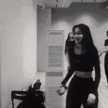 a black and white photo of a woman in a crop top dancing
