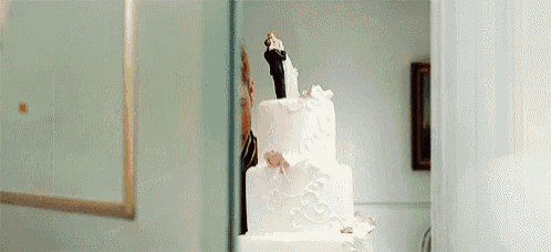 a wedding cake with a bride and groom figurine on top .
