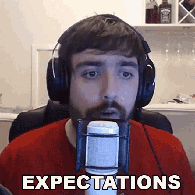 a man wearing headphones stands in front of a microphone with the word expectations written below him