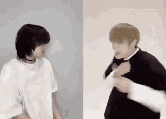two young men are standing next to each other in front of a white wall .