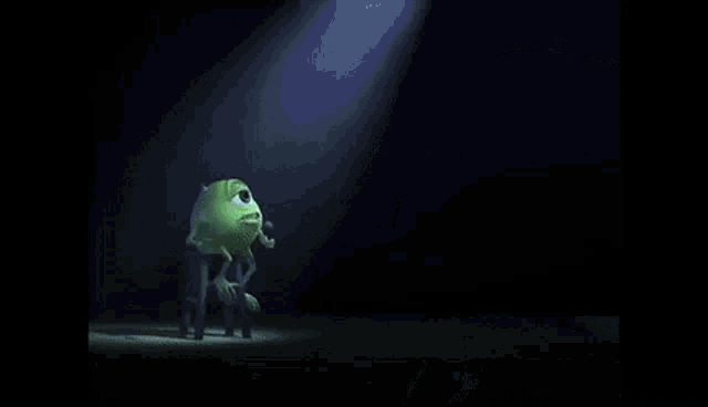 mike wazowski from monsters inc is holding a microphone and making a funny face .