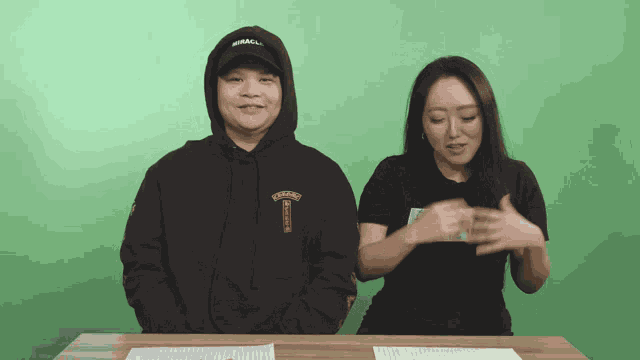 a man and a woman are sitting at a table and the man is wearing a hoodie that says chicago