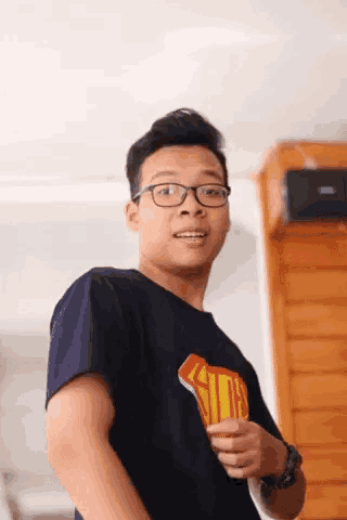 a young man wearing glasses and a shirt that says superman