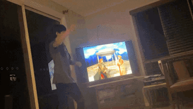 a man is dancing in front of a tv screen