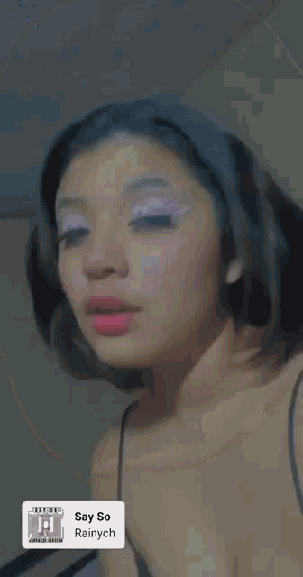 a close up of a woman 's face with the words say so rainych on the bottom right