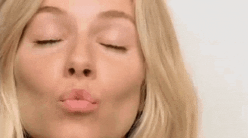a close up of a woman 's face with her mouth open and her eyes closed .