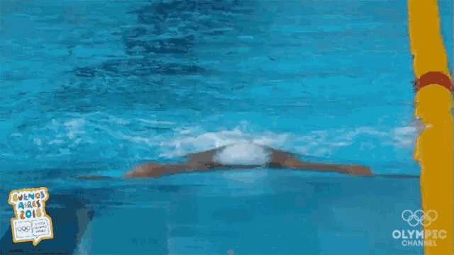 a man is swimming in a pool with the olympic channel logo on the bottom