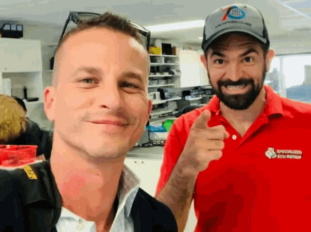 two men are posing for a picture and one is wearing a shirt that says specialized sku repair