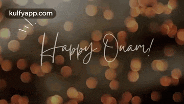 the words happy onam are written in cursive on a blurry background .
