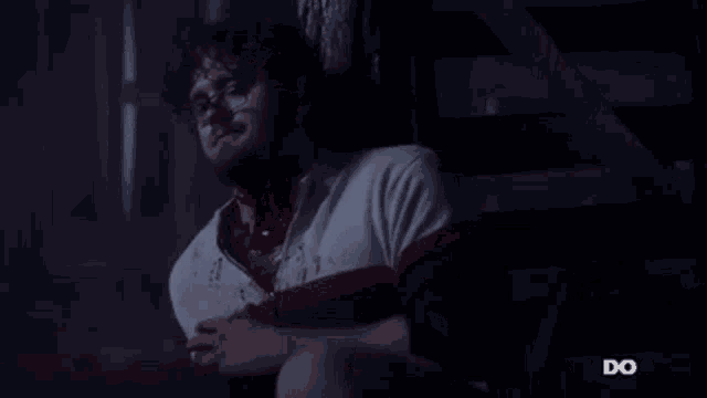 a man is sitting on a set of stairs with blood coming out of his chest .
