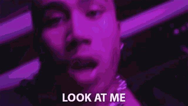 a close up of a person 's face with the words look at me written in white