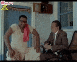 two men are sitting in a room talking to each other .