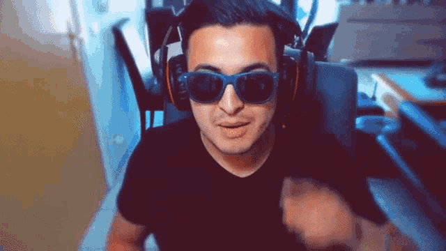 a man wearing headphones and sunglasses is making a funny face