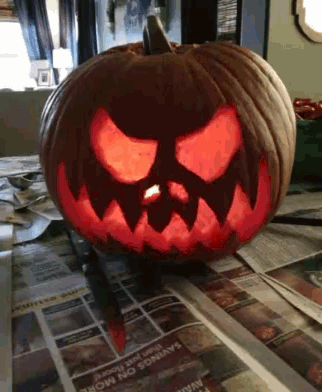 a carved pumpkin sits on a table next to a newspaper with savings on more written on it