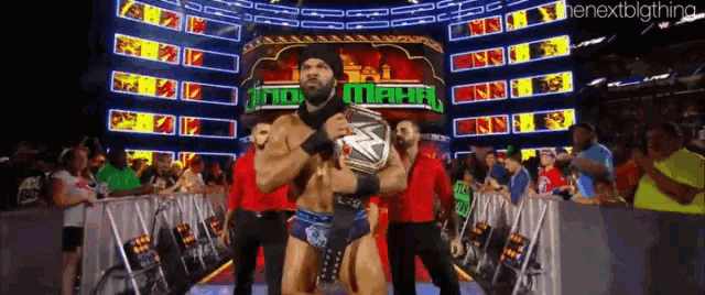 a man in a cowboy hat is holding a wrestling championship belt
