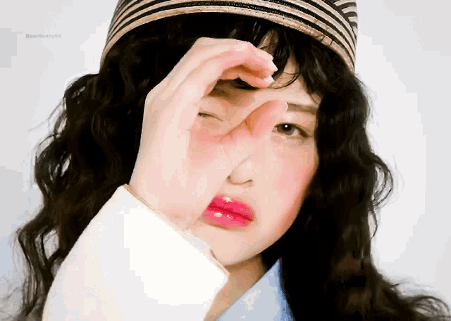 a woman wearing a striped hat covering her face