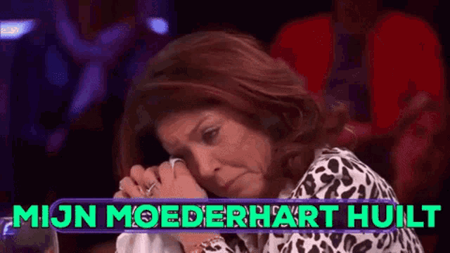a woman is crying in front of a sign that says " mijn moederhart vuilt "