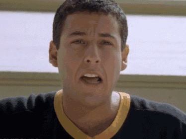 a man wearing a black shirt with a yellow collar is making a face