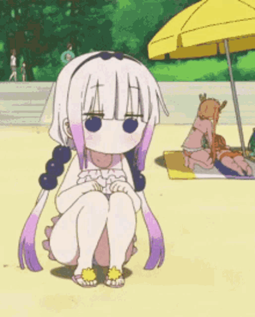 a girl in a bathing suit is kneeling down on the beach next to a crab .