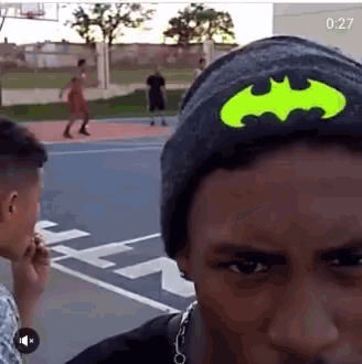 a man wearing a batman hat looks at the camera with the time of 0:27