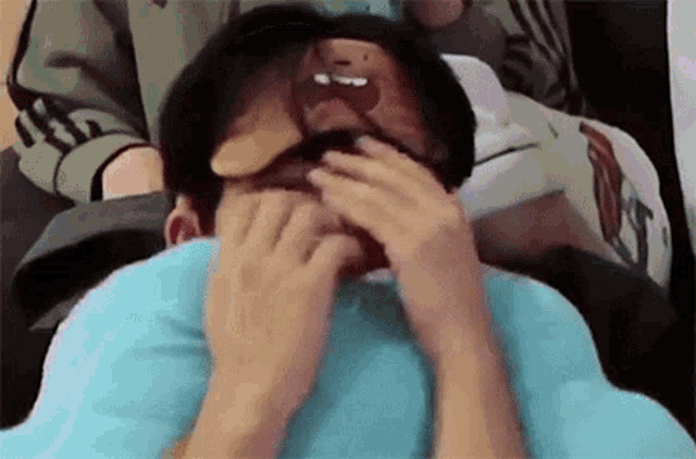 a man is laying on a bed with a pillow on his face .