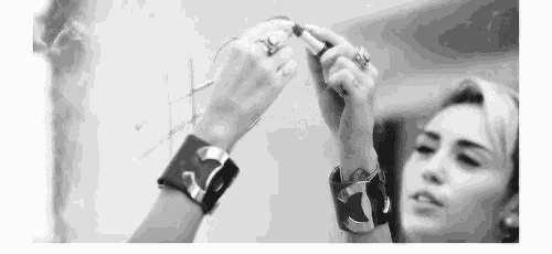 a woman wearing bracelets and rings is looking at herself in the mirror .