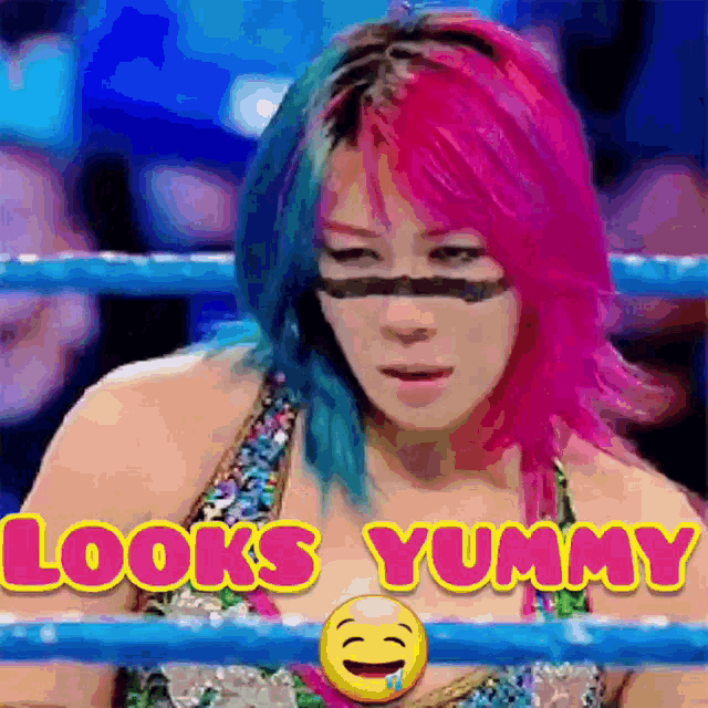 a woman with pink and blue hair is in a boxing ring with the words looks yummy behind her