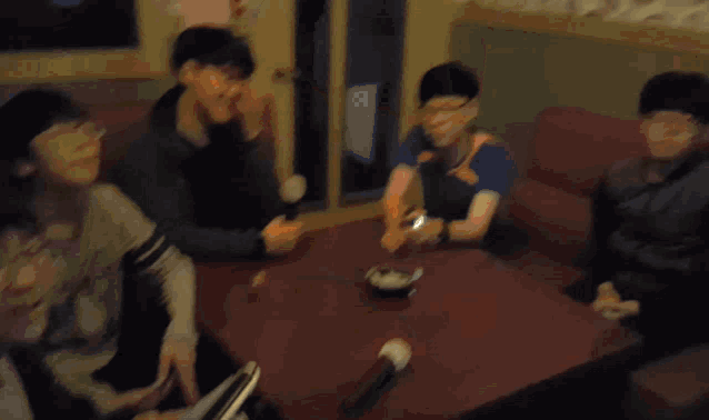a man wearing glasses sits on a red couch next to another man wearing glasses
