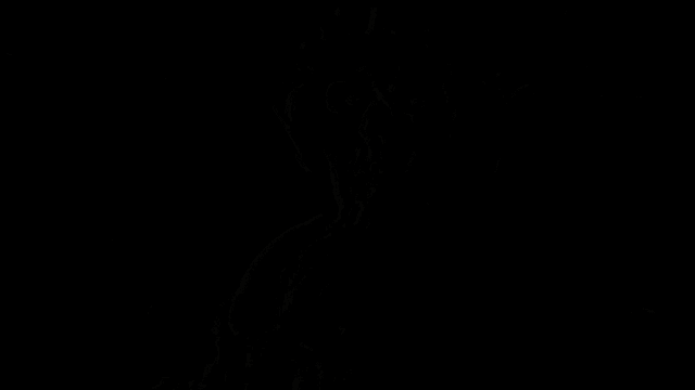 a man wearing a skull mask and headphones is sitting in a dark room .