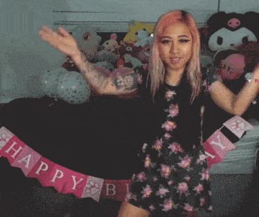 a woman is holding a happy birthday banner