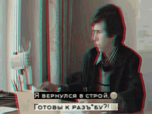 a man sits at a desk in front of a computer with the words " я вернулся в строй " on the bottom