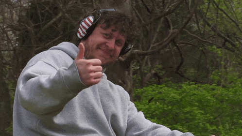 a man wearing headphones and giving a thumbs up