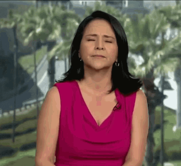 a woman in a pink tank top is making a funny face