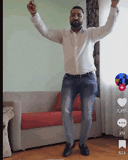 a man in a white shirt and jeans is dancing in a living room