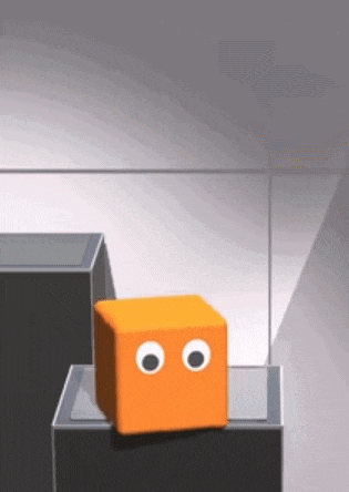 an orange cube with googly eyes is sitting on top of a stack of black blocks .