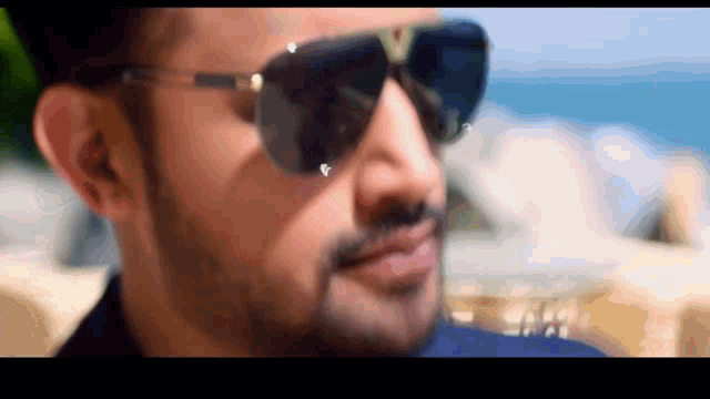 a man with a beard wearing sunglasses with the letter v on the lens