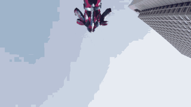 a person in a red and blue suit is flying through the air