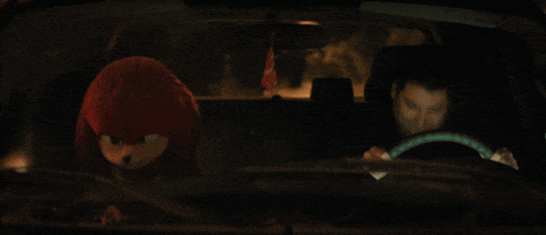 a man driving a car with a stuffed animal in the back