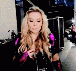 a woman in a black and pink outfit is standing in a dark room